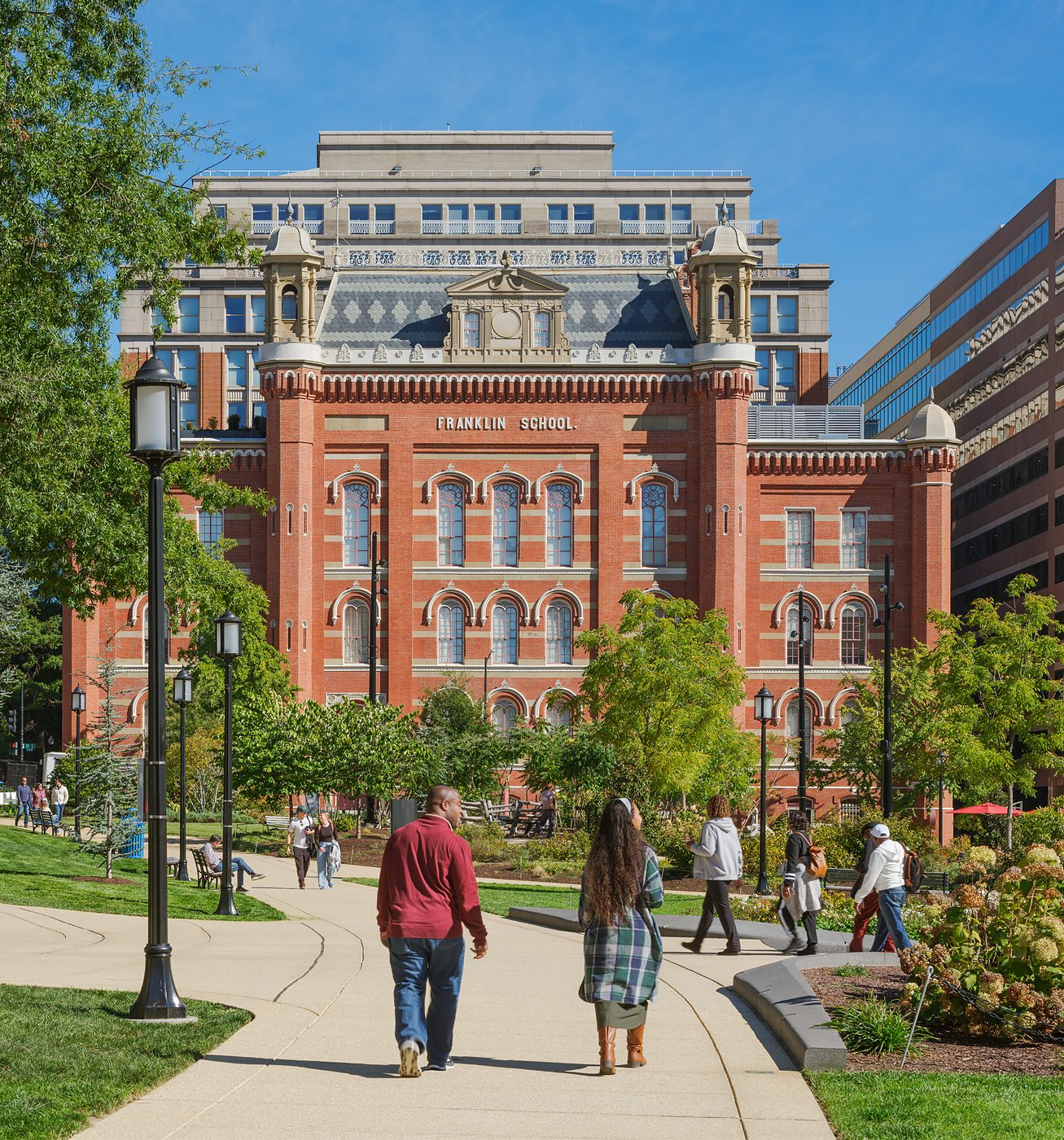 People walking past the historic Franklin School at Franklin Park